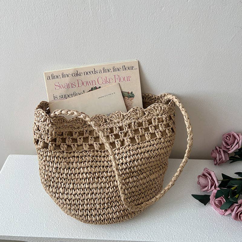 Woven basket with books and flowers on a white surface