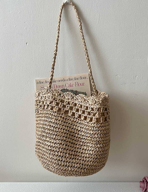 Woven handbag with a handle on a plain background