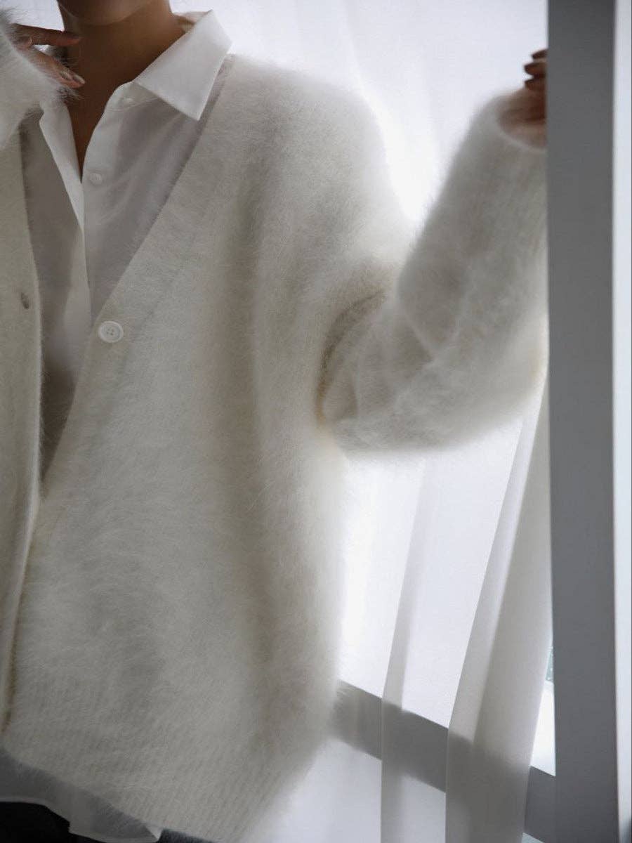 White sweater over a white shirt with a blurred background