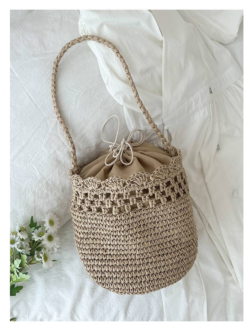 Beige woven handbag with a drawstring on a white fabric background