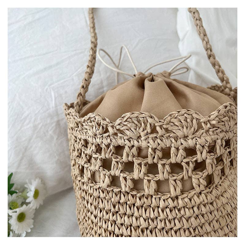 Beige woven handbag with drawstring top on a white background